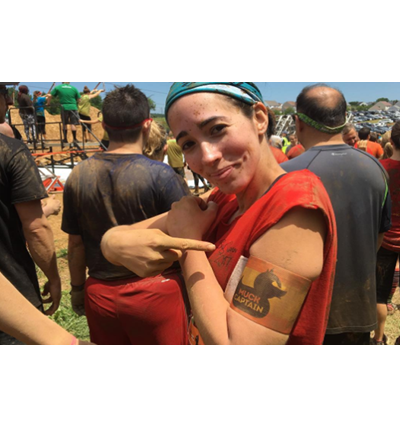 Young Female MS Patient Rachael Proudly points to her shoulder badge during the Philadelphia Muckfest during the mud run for MS